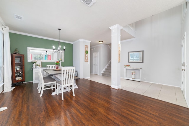 18914 Woodglen Shadows Dr, Humble, TX 77346 - dining room with stairs, a chandelier, wood finished floors, crown molding, and decorative columns