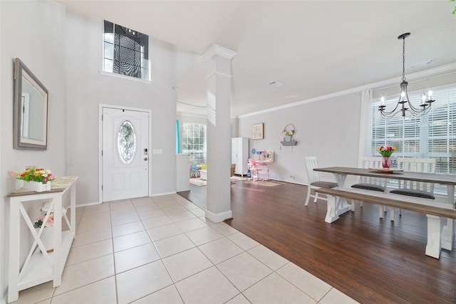 18914 Woodglen Shadows Dr, Humble, TX 77346 - foyer with light tile patterned floors, a chandelier, and crown molding