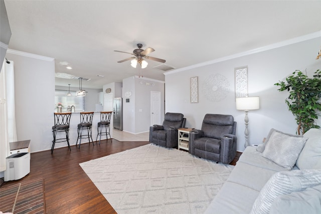 18914 Woodglen Shadows Dr, Humble, TX 77346 - living area with a ceiling fan, ornamental molding, and dark wood-style flooring