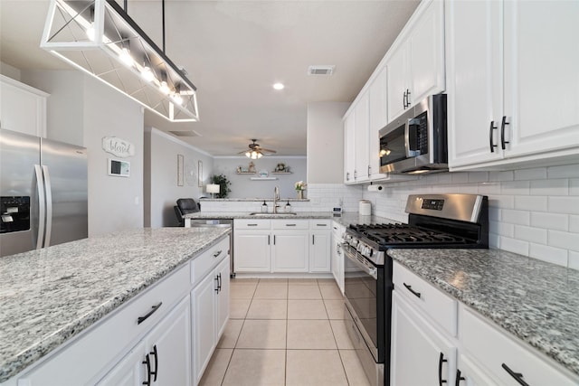 18914 Woodglen Shadows Dr, Humble, TX 77346 - kitchen featuring stainless steel appliances, decorative backsplash, white cabinets, and light tile patterned floors