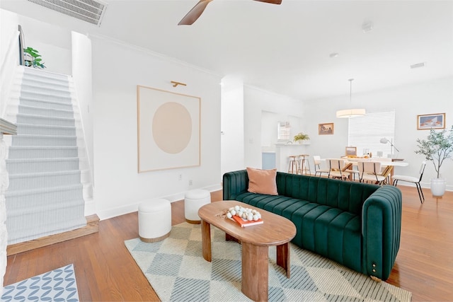 2909 Arbor St, Houston, TX 77004 - living room with light wood finished floors, ceiling fan, crown molding, and stairway