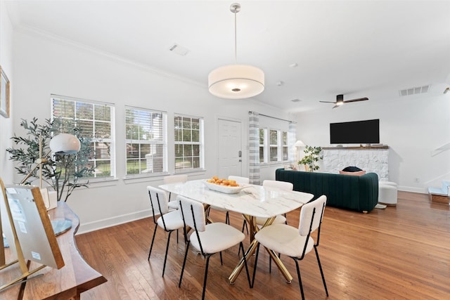2909 Arbor St, Houston, TX 77004 - dining area featuring plenty of natural light, wood finished floors, crown molding, ceiling fan, and a fireplace