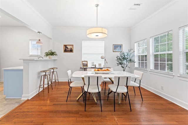 2909 Arbor St, Houston, TX 77004 - dining room featuring plenty of natural light, crown molding, and wood finished floors