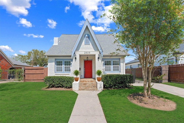 2909 Arbor St, Houston, TX 77004 - tudor home featuring a gate, brick siding, roof with shingles, and a chimney