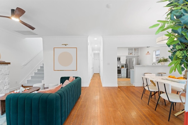 2909 Arbor St, Houston, TX 77004 - living area featuring stairway, ornamental molding, light wood-style flooring, and a ceiling fan