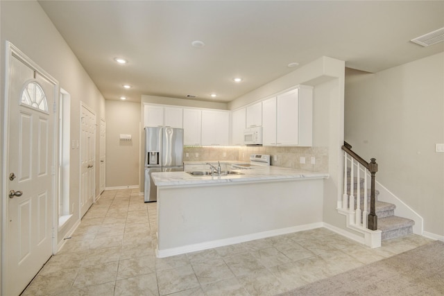 527 Dr Martin Luther King Jr Dr Unit D, La Porte, TX 77571 - kitchen with white appliances, white cabinetry, a peninsula, backsplash, and recessed lighting