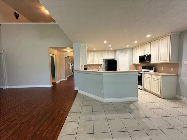 12807 Stratford Heights Dr, Sugar Land, TX 77498 - kitchen with gas range gas stove, refrigerator, black microwave, light countertops, and recessed lighting