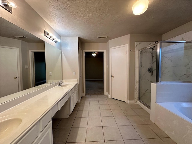 12807 Stratford Heights Dr, Sugar Land, TX 77498 - full bathroom featuring double vanity, a marble finish shower, a garden tub, a textured ceiling, and tile patterned flooring
