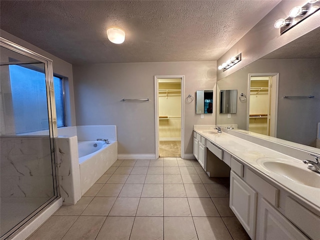 12807 Stratford Heights Dr, Sugar Land, TX 77498 - full bathroom featuring a bath, a walk in closet, double vanity, a shower stall, and a textured ceiling