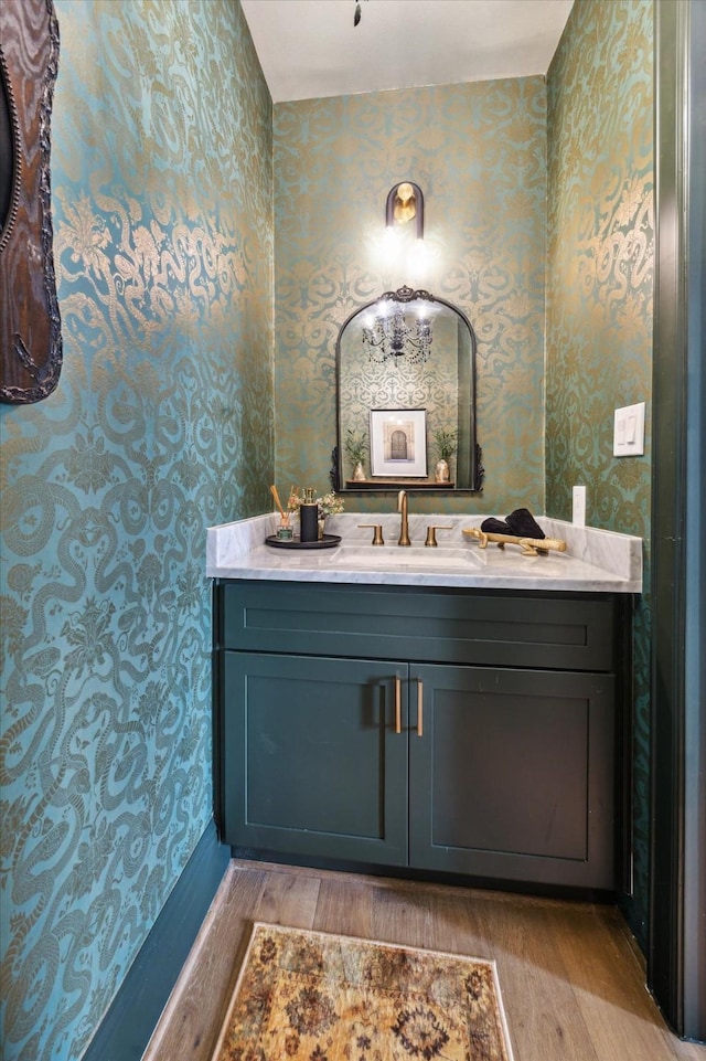 619 W 26th St, Houston, TX 77008 - bathroom featuring wallpapered walls, wood finished floors, and vanity