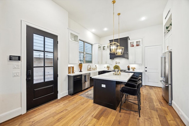 619 W 26th St, Houston, TX 77008 - kitchen with appliances with stainless steel finishes, a center island, a chandelier, light countertops, and tasteful backsplash