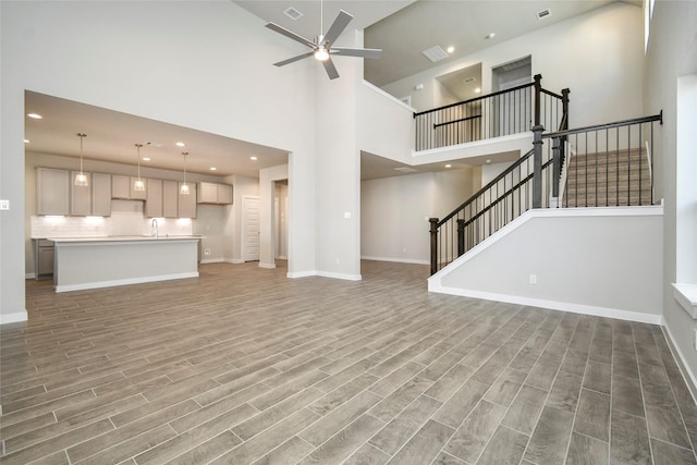 11102 Gardenia Creek Dr, Houston, TX 77044 - unfurnished living room featuring a ceiling fan, light wood-type flooring, a towering ceiling, stairway, and recessed lighting