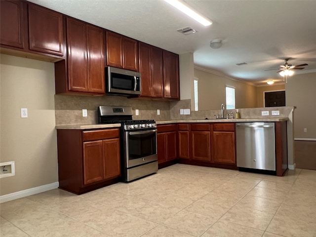 9515 Lower Ridgeway, Houston, TX 77075 - kitchen featuring appliances with stainless steel finishes, light countertops, a peninsula, a ceiling fan, and ornamental molding