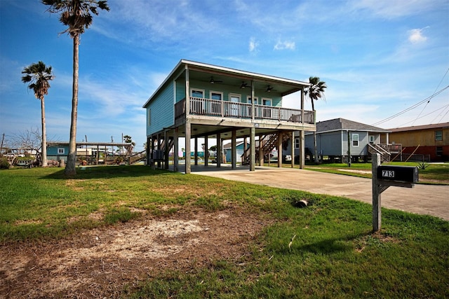 713 Copano Cove Rd, Rockport, TX 78382 - coastal inspired home featuring a carport, ceiling fan, stairs, a front yard, and covered porch