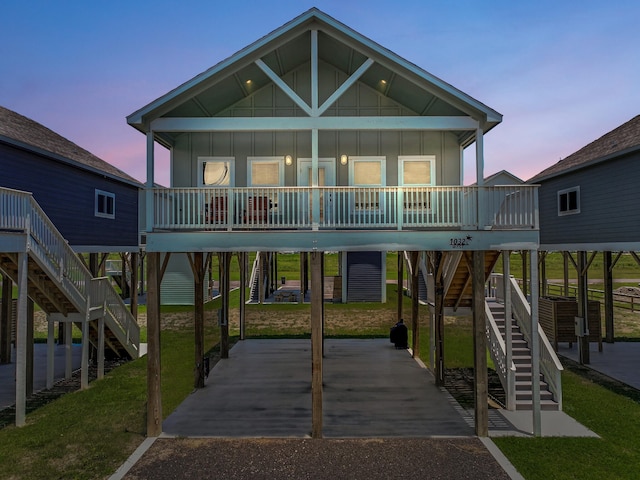 1032 Sunset Cir W, Crystal Beach, TX 77650 - back of house featuring stairs, board and batten siding, covered porch, and a yard