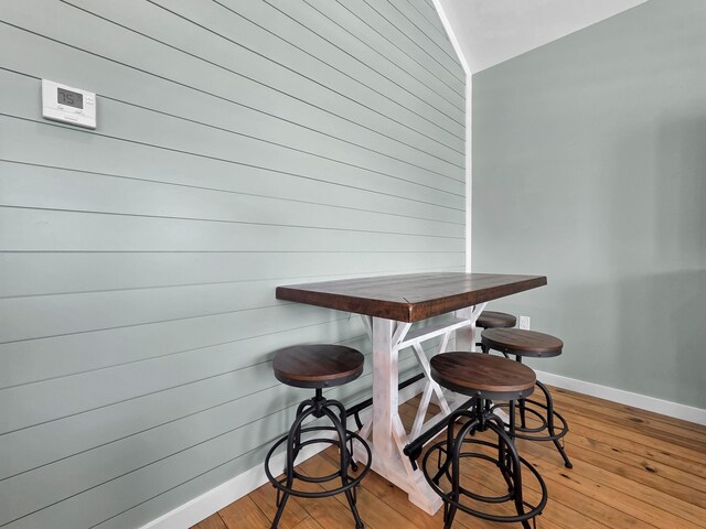 1032 Sunset Cir W, Crystal Beach, TX 77650 - dining room with light wood finished floors, wooden walls, and lofted ceiling