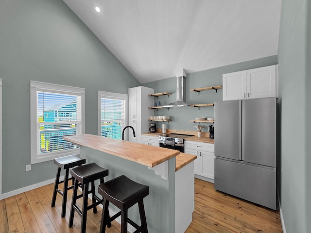1032 Sunset Cir W, Crystal Beach, TX 77650 - kitchen featuring stainless steel appliances, butcher block counters, open shelves, white cabinetry, and a breakfast bar