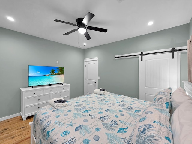 1032 Sunset Cir W, Crystal Beach, TX 77650 - bedroom featuring light wood-style floors, a barn door, recessed lighting, and ceiling fan