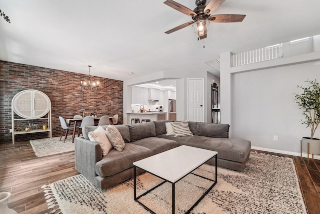 87 E Greenhill Terrace Pl, The Woodlands, TX 77382 - living room featuring brick wall, wood finished floors, ceiling fan, and a chandelier