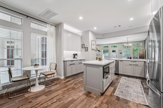 87 E Greenhill Terrace Pl, The Woodlands, TX 77382 - kitchen with stainless steel appliances, gray cabinets, a kitchen island, dark wood-style floors, and recessed lighting