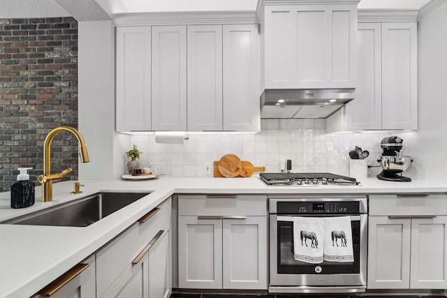 87 E Greenhill Terrace Pl, The Woodlands, TX 77382 - kitchen with appliances with stainless steel finishes, decorative backsplash, light countertops, under cabinet range hood, and white cabinetry