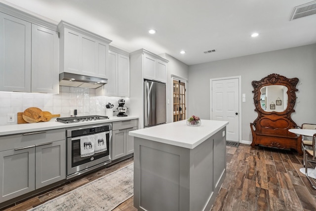 87 E Greenhill Terrace Pl, The Woodlands, TX 77382 - kitchen with appliances with stainless steel finishes, gray cabinetry, dark wood finished floors, decorative backsplash, and recessed lighting