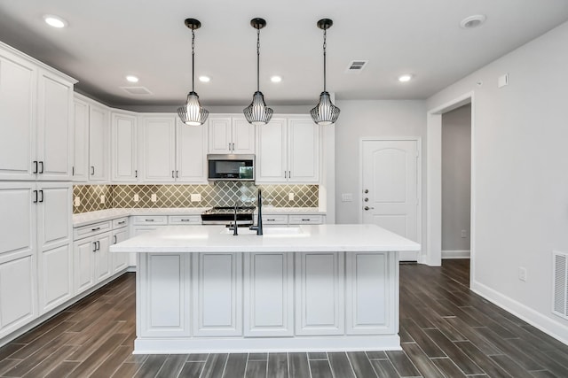6804 Westview Dr Unit 3405, Houston, TX 77055 - kitchen featuring stainless steel microwave, light countertops, dark wood-style flooring, and recessed lighting