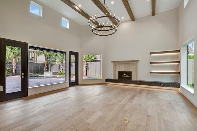 4316 Dickson St, Houston, TX 77007 - unfurnished living room with a chandelier, a high ceiling, beam ceiling, wood finished floors, and a tile fireplace