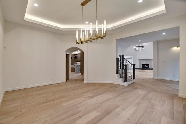 4316 Dickson St, Houston, TX 77007 - spare room with a tray ceiling, arched walkways, recessed lighting, light wood-type flooring, and a chandelier