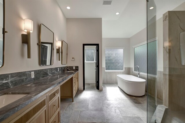 4316 Dickson St, Houston, TX 77007 - bathroom with a freestanding tub, double vanity, walk in shower, a wainscoted wall, and recessed lighting