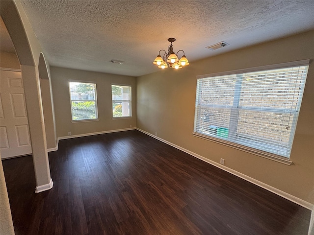 18322 Valiant Brook Ct, Humble, TX 77346 - spare room with arched walkways, dark wood-style flooring, a chandelier, and a textured ceiling