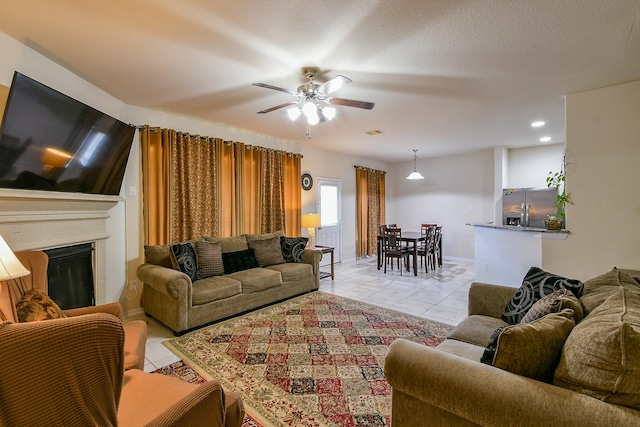 4134 Loft Square Pl, Humble, TX 77346 - living area with light tile patterned floors, a glass covered fireplace, and a ceiling fan