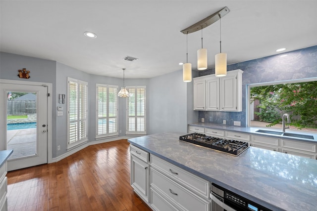 12814 Josey Creek Ct, Cypress, TX 77433 - kitchen with stainless steel gas stovetop, white cabinets, decorative light fixtures, wood-type flooring, and tasteful backsplash