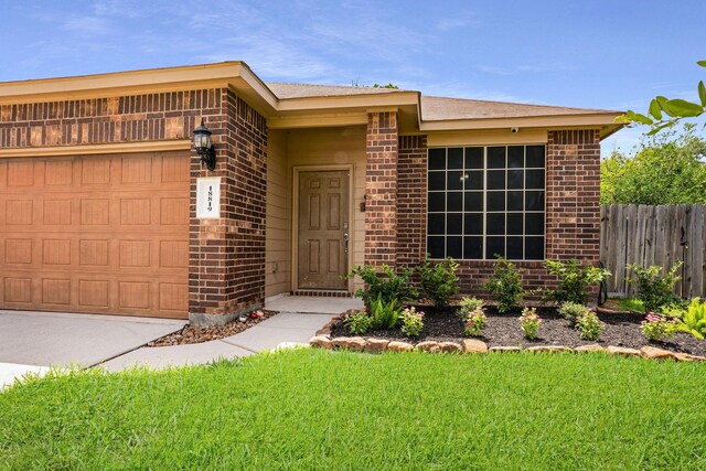 18819 Deer Trace Dr, Crosby, TX 77532 - view of front of home with brick siding, an attached garage, and driveway