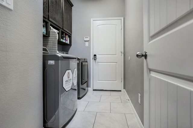 18819 Deer Trace Dr, Crosby, TX 77532 - laundry area featuring cabinet space, independent washer and dryer, light tile patterned floors, and a textured wall