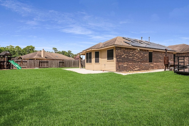 18819 Deer Trace Dr, Crosby, TX 77532 - back of property featuring a patio, solar panels, a fenced backyard, a playground, and brick siding
