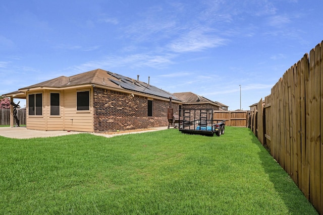 18819 Deer Trace Dr, Crosby, TX 77532 - back of house featuring solar panels, a fenced backyard, a patio area, and brick siding