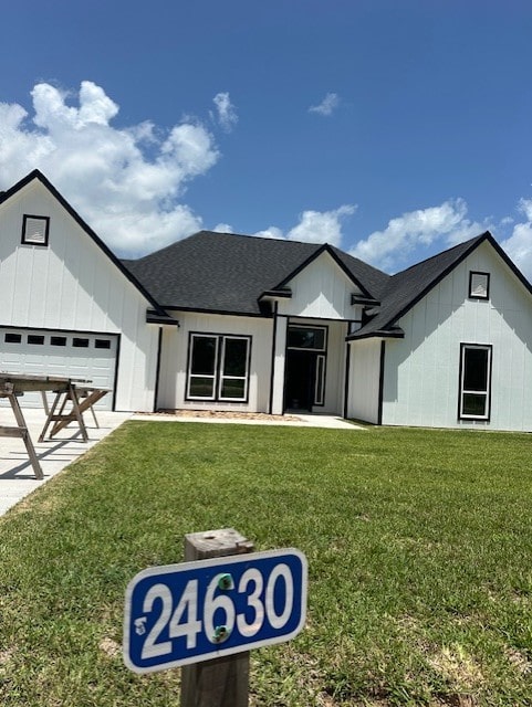 24630 Cavan St, Hempstead, TX 77445 - modern inspired farmhouse with a front yard, a garage, a shingled roof, concrete driveway, and board and batten siding