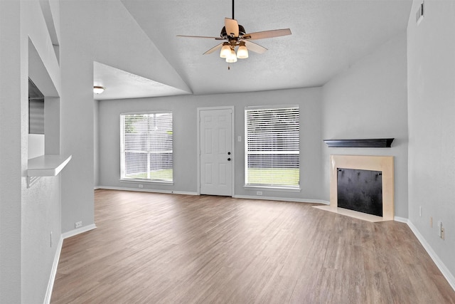 2307 Pine Cone Dr, Houston, TX 77339 - unfurnished living room with wood finished floors, a fireplace with flush hearth, lofted ceiling, a ceiling fan, and a textured ceiling