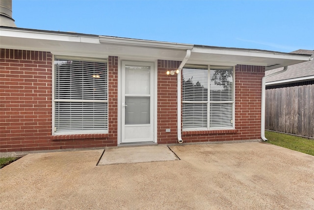 2307 Pine Cone Dr, Houston, TX 77339 - view of exterior entry featuring brick siding and a patio area
