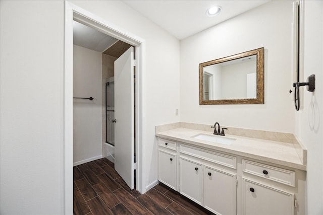3002 Durban Dr, Houston, TX 77043 - full bath featuring vanity, shower / bath combination with glass door, wood tiled floors, and recessed lighting