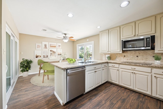 3002 Durban Dr, Houston, TX 77043 - kitchen featuring appliances with stainless steel finishes, a peninsula, dark wood finished floors, recessed lighting, and backsplash