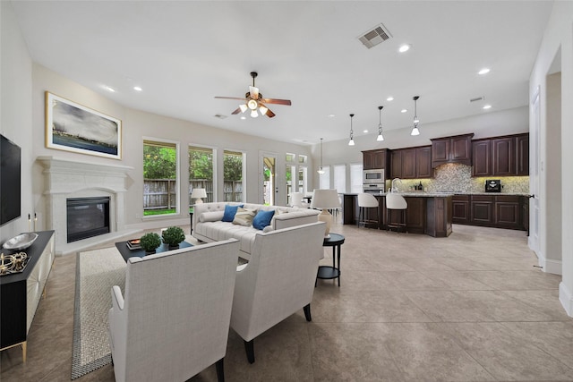 23414 Fauburg Dr, New Caney, TX 77357 - living room with a ceiling fan, a fireplace, recessed lighting, and light tile patterned floors