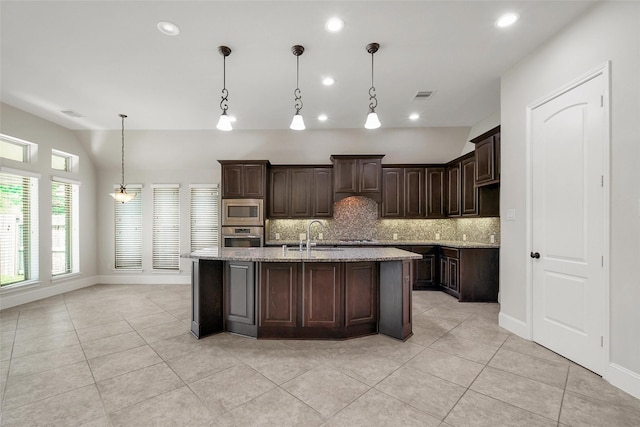 23414 Fauburg Dr, New Caney, TX 77357 - kitchen featuring appliances with stainless steel finishes, backsplash, light tile patterned floors, dark brown cabinetry, and recessed lighting
