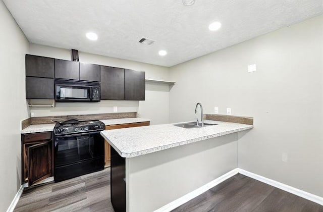 15110 Runbell Pl, Houston, TX 77095 - kitchen with black appliances, dark wood finished floors, a peninsula, light countertops, and recessed lighting