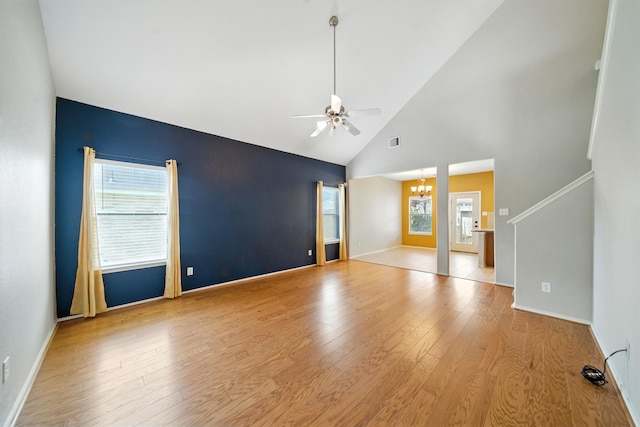 18123 Hillock Glen Ln, Cypress, TX 77429 - empty room with a chandelier, high vaulted ceiling, a ceiling fan, light wood finished floors, and stairway