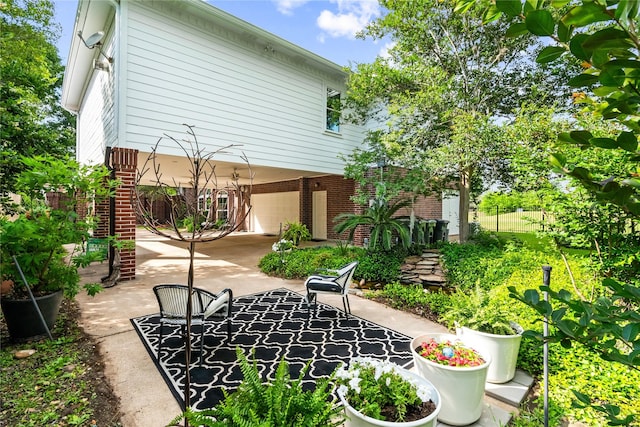 1734 Forestlake Dr, Sugar Land, TX 77479 - rear view of property featuring brick siding, driveway, a patio area, and an attached garage