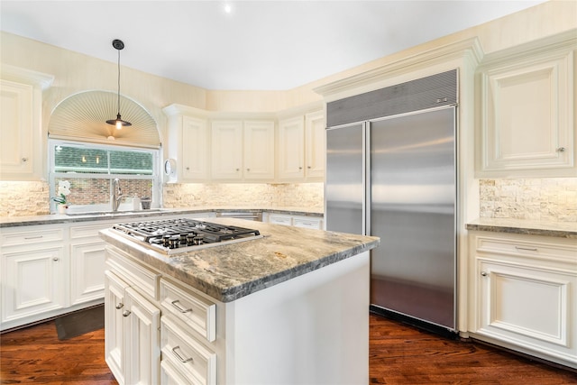 1734 Forestlake Dr, Sugar Land, TX 77479 - kitchen featuring appliances with stainless steel finishes, backsplash, light stone countertops, a center island, and white cabinets