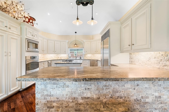 1734 Forestlake Dr, Sugar Land, TX 77479 - kitchen with a peninsula, built in appliances, tasteful backsplash, and decorative light fixtures