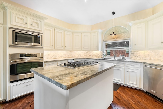 1734 Forestlake Dr, Sugar Land, TX 77479 - kitchen featuring appliances with stainless steel finishes, decorative backsplash, dark wood-style floors, hanging light fixtures, and light stone counters